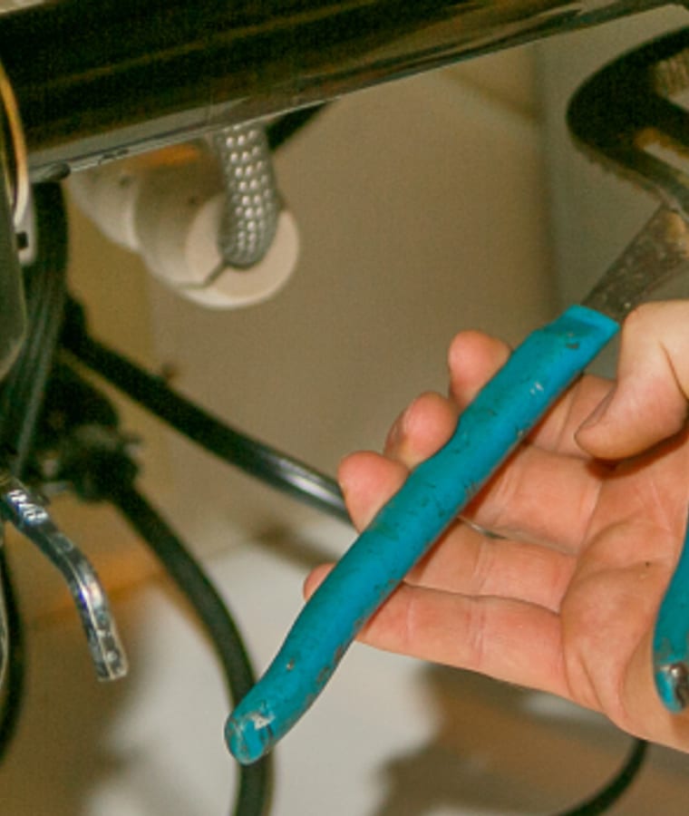 A plumber's hands and tool at work, from Gormley's residential photography